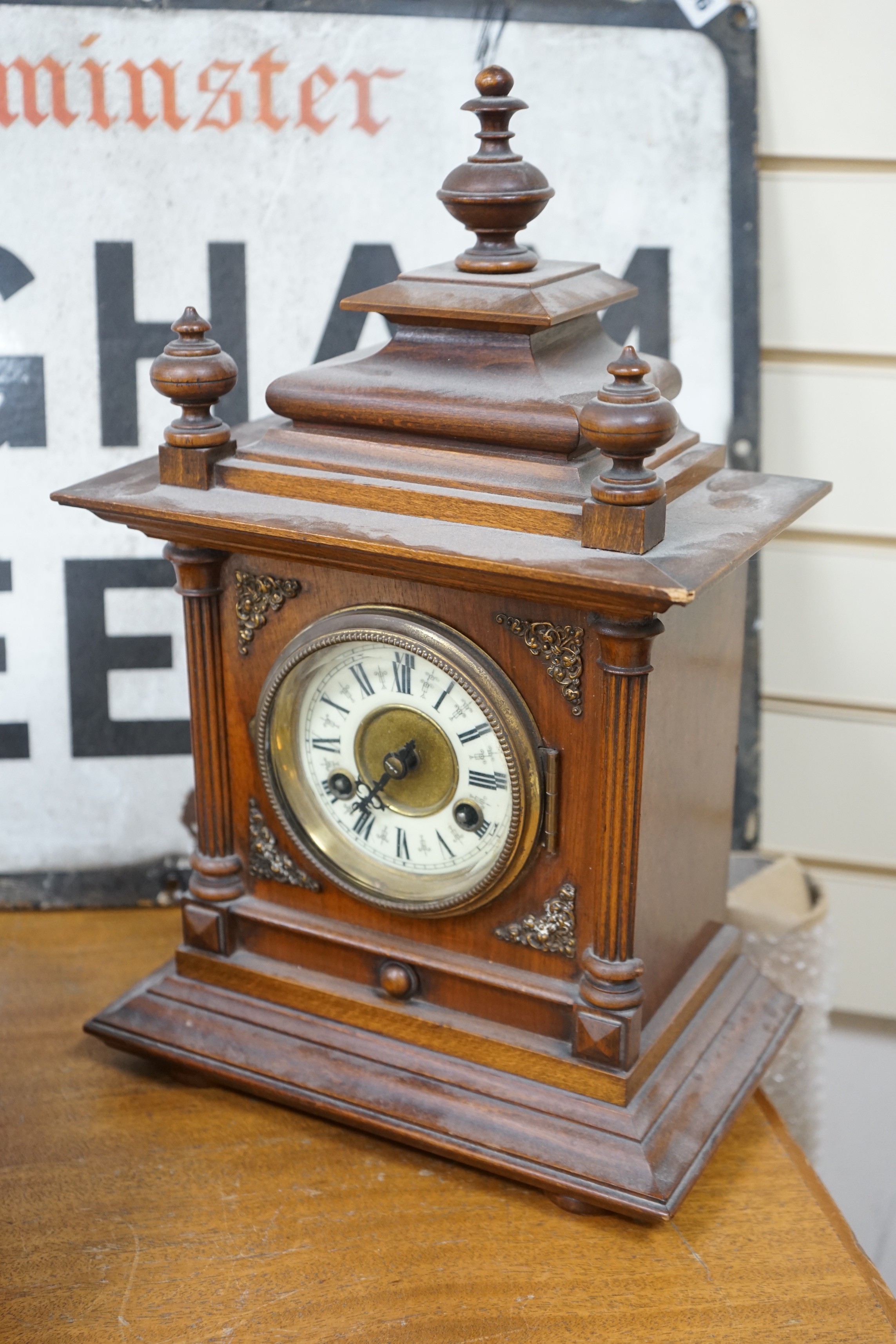 A 19th century German walnut mantel clock with key and pendulum, 40cm tall